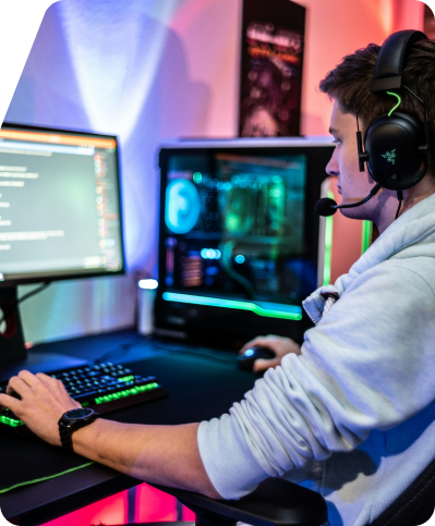 A person gaming with a lit-up PC and headphones